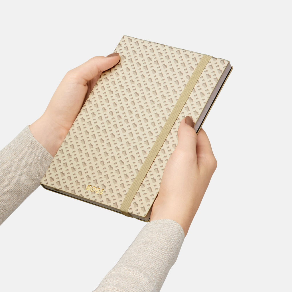 Hand holding a woven notebook with a plain background